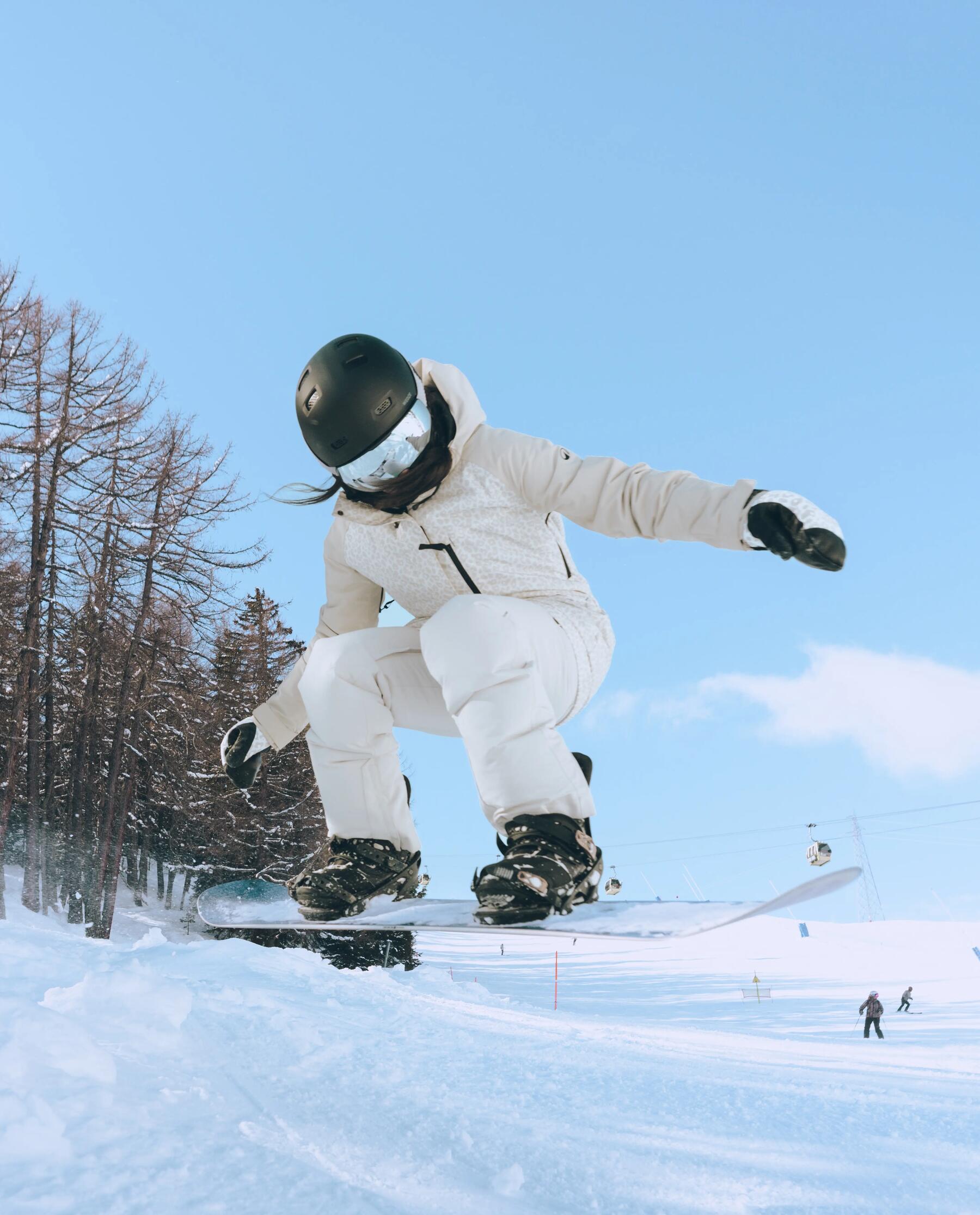 Man standing in front of cabin with his snowboard
