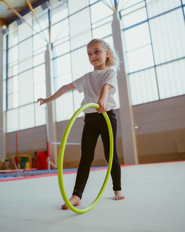 Ein Mädchen trainiert mit einem Gymnastikreifen.