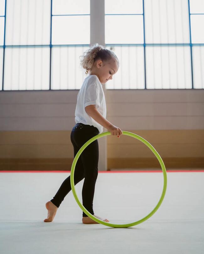 Ein Mädchen trainiert mit einem Gymnastikreifen.