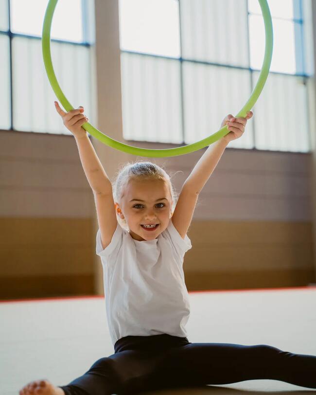 Ein Mädchen spielt mit einem Gymnastikreifen.