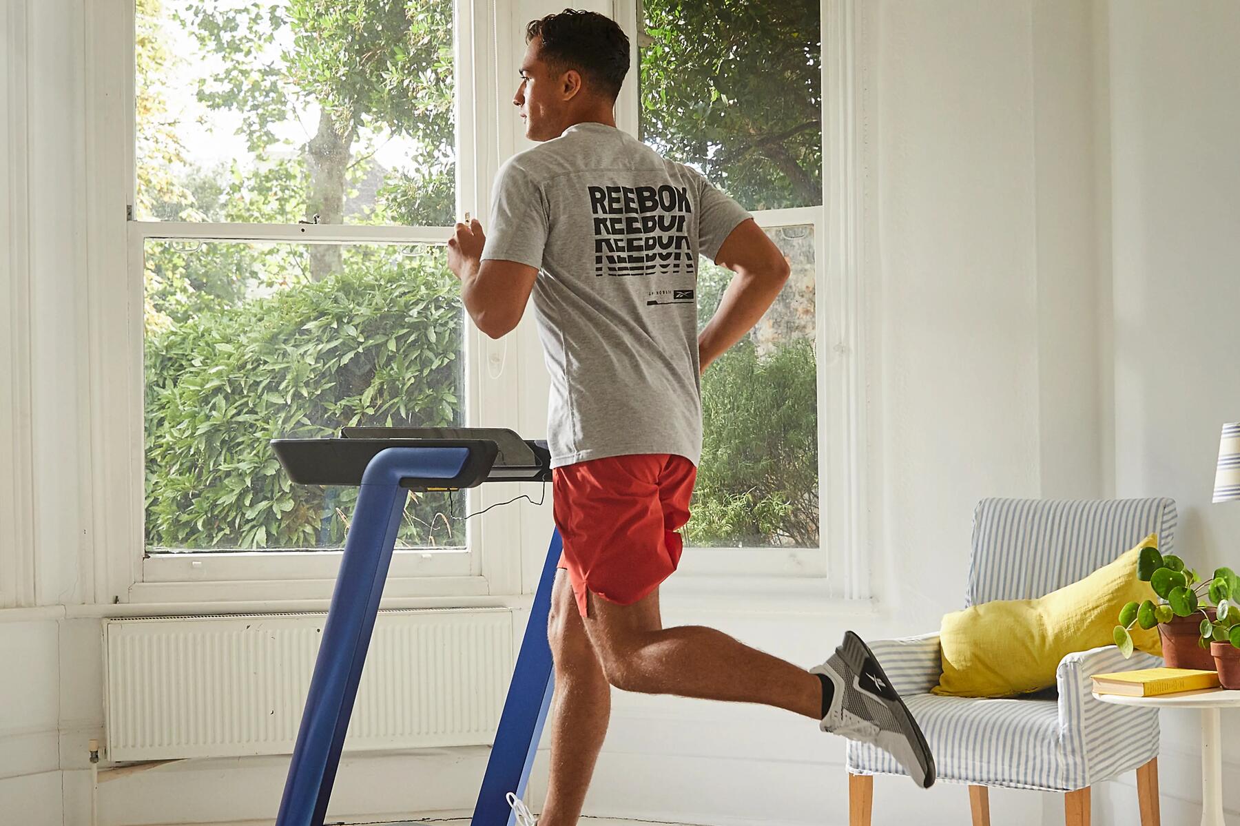 Ein Mann nutzt ein Laufband im Wohnzimmer