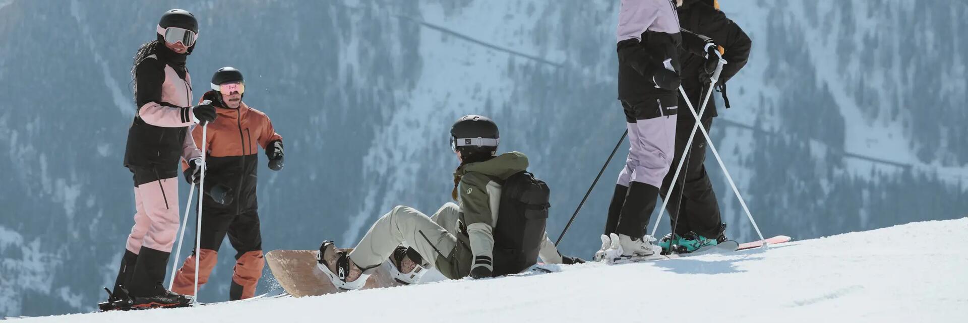 Osoby ze sprzętem narciarskim i snowboardowym rozmawiające o bezpieczeństwie na stoku