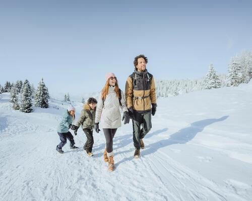 Familie mit Kinder geht wandern im Schnee