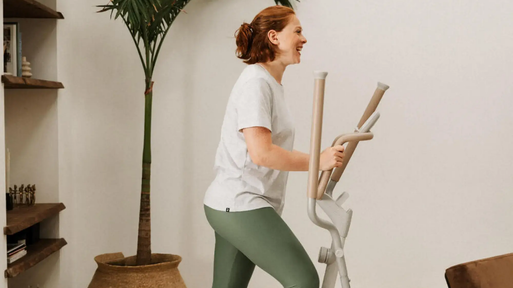 Eine Frau steht auf dem Crosstrainer im Wohnzimmer!