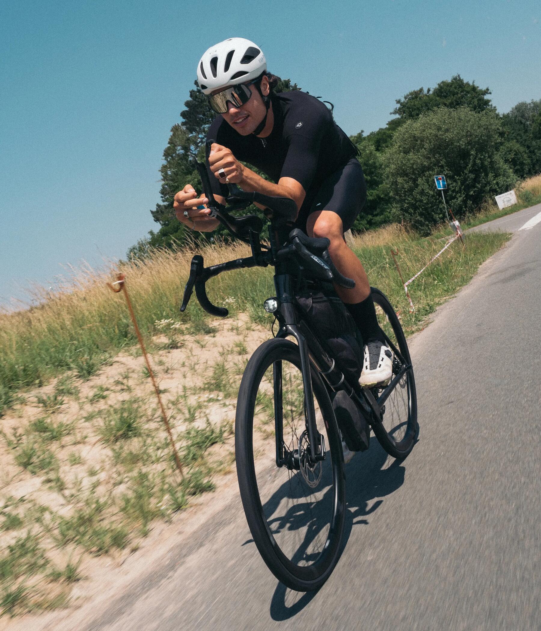 Mann fährt mit seinem schwarzen Rennrad mit guten Bremsbelägen
