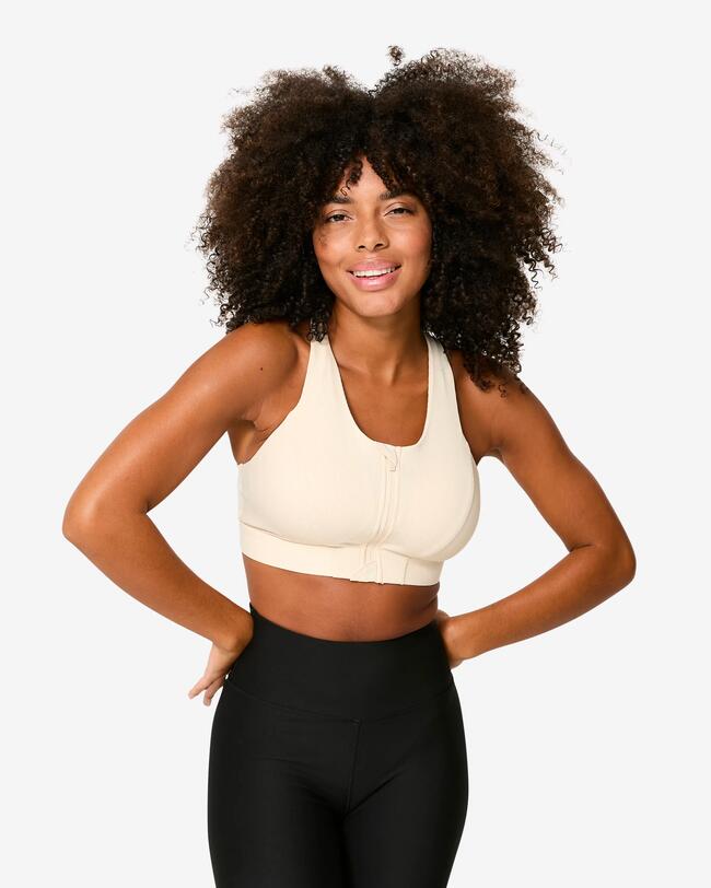 Eine Frau trägt einen Sport-BH in der Farbe beige.