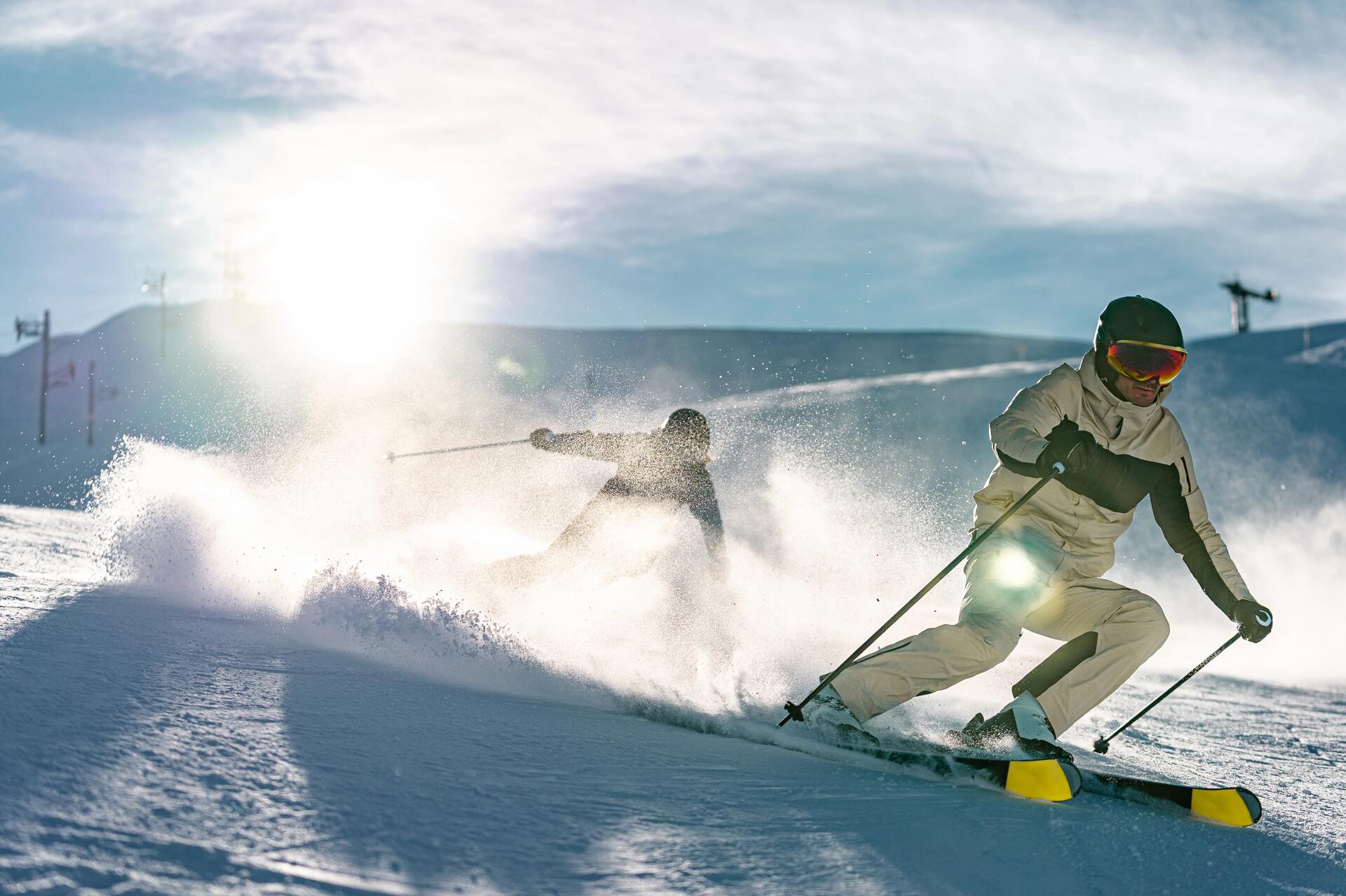 Une femme qui regarde la pente de ski avec ses lunettes sur la tête