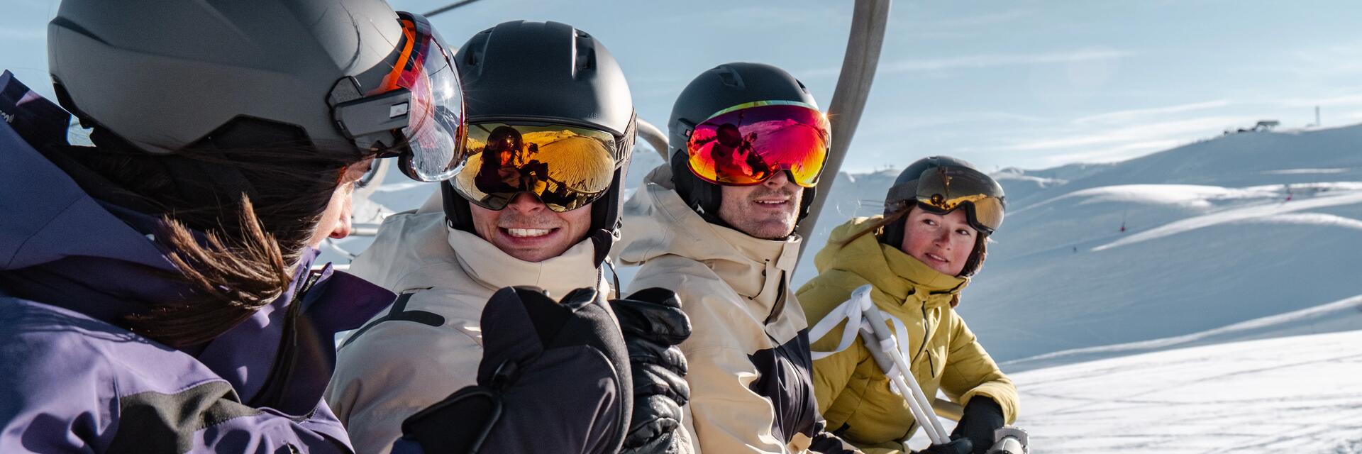 skieurs avec leur casque sur un télésiège à la montagne