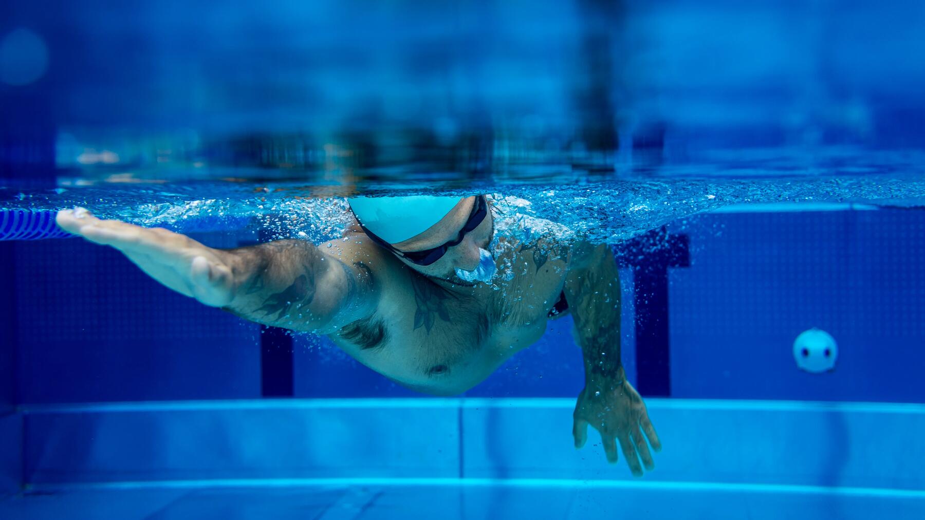 Person nutzt Schwimmbrille im Schwimmbad