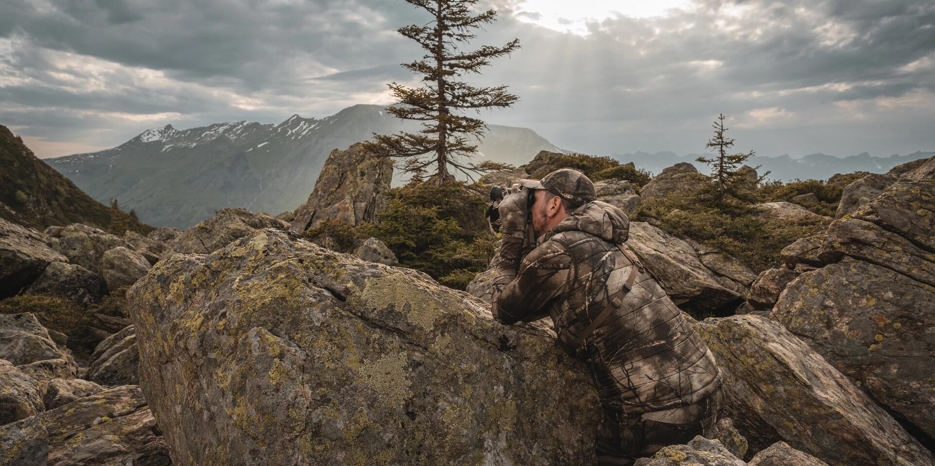 Un chasseur à l'approche au milieu des rochers en pleine montagne