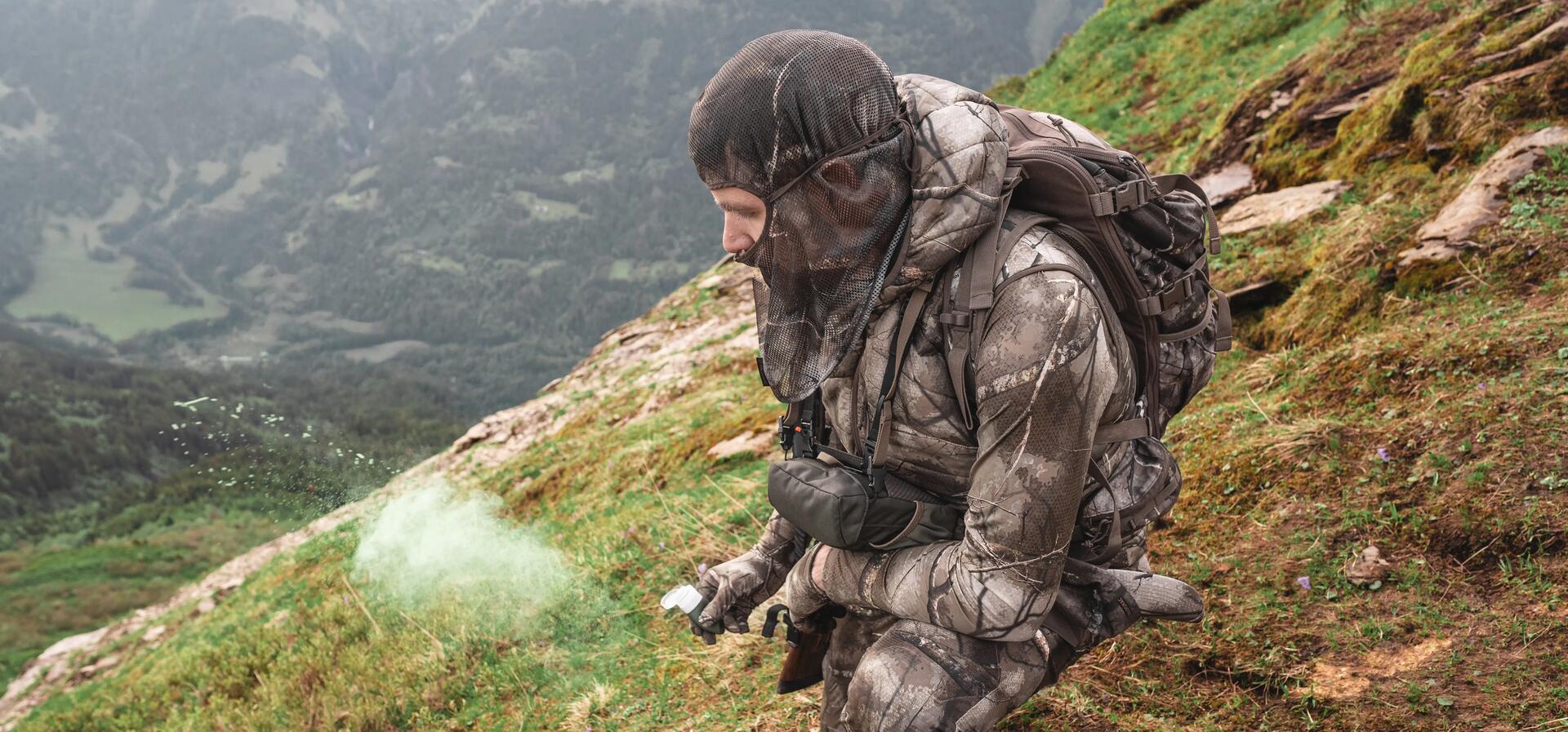 Un chasseur à l'approche utilisant une poire à vent pour connaitre le sens du vent