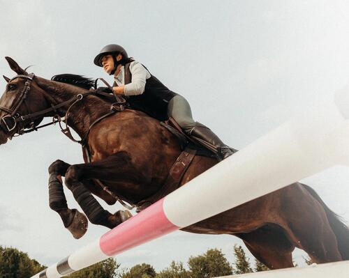 Eine Frau reitet mit Reitschuhen, Reitstiefeln und Chaps