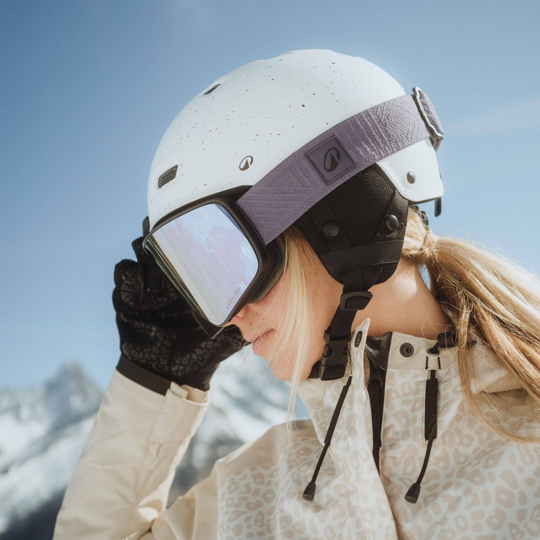 Mann hat Schnee auf der Skibrille und im Gesicht