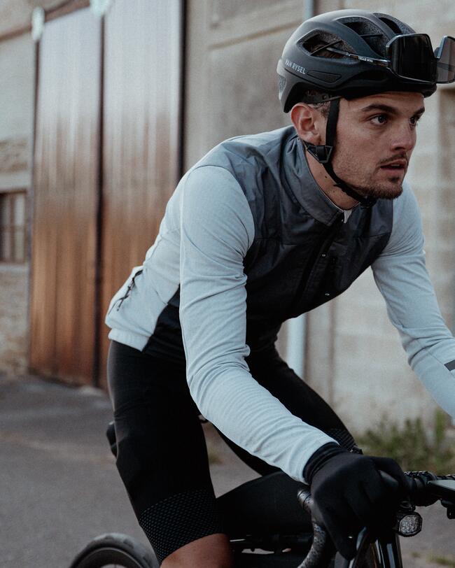 Mann mit blauem Radtrikot, Helm, Sonnenbrille und kurzer Radhose