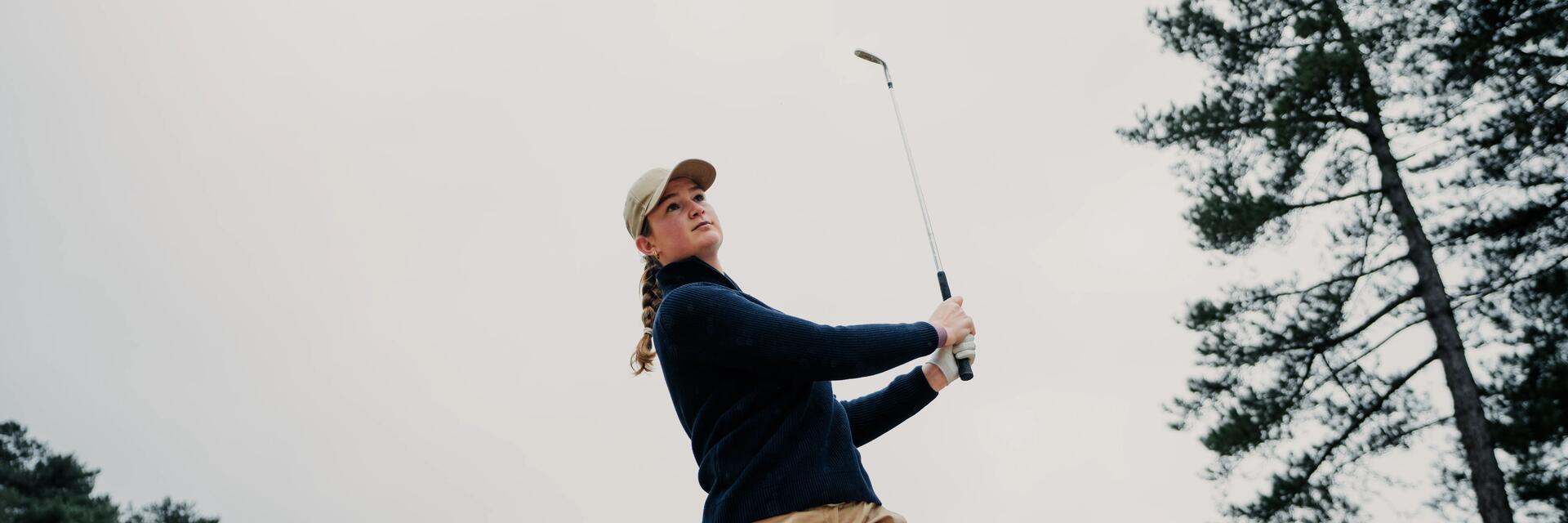 Kobieta wykonująca zamach kijem golfowym