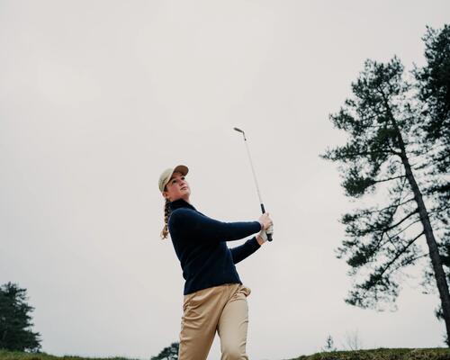 Kobieta wykonująca zamach kijem golfowym