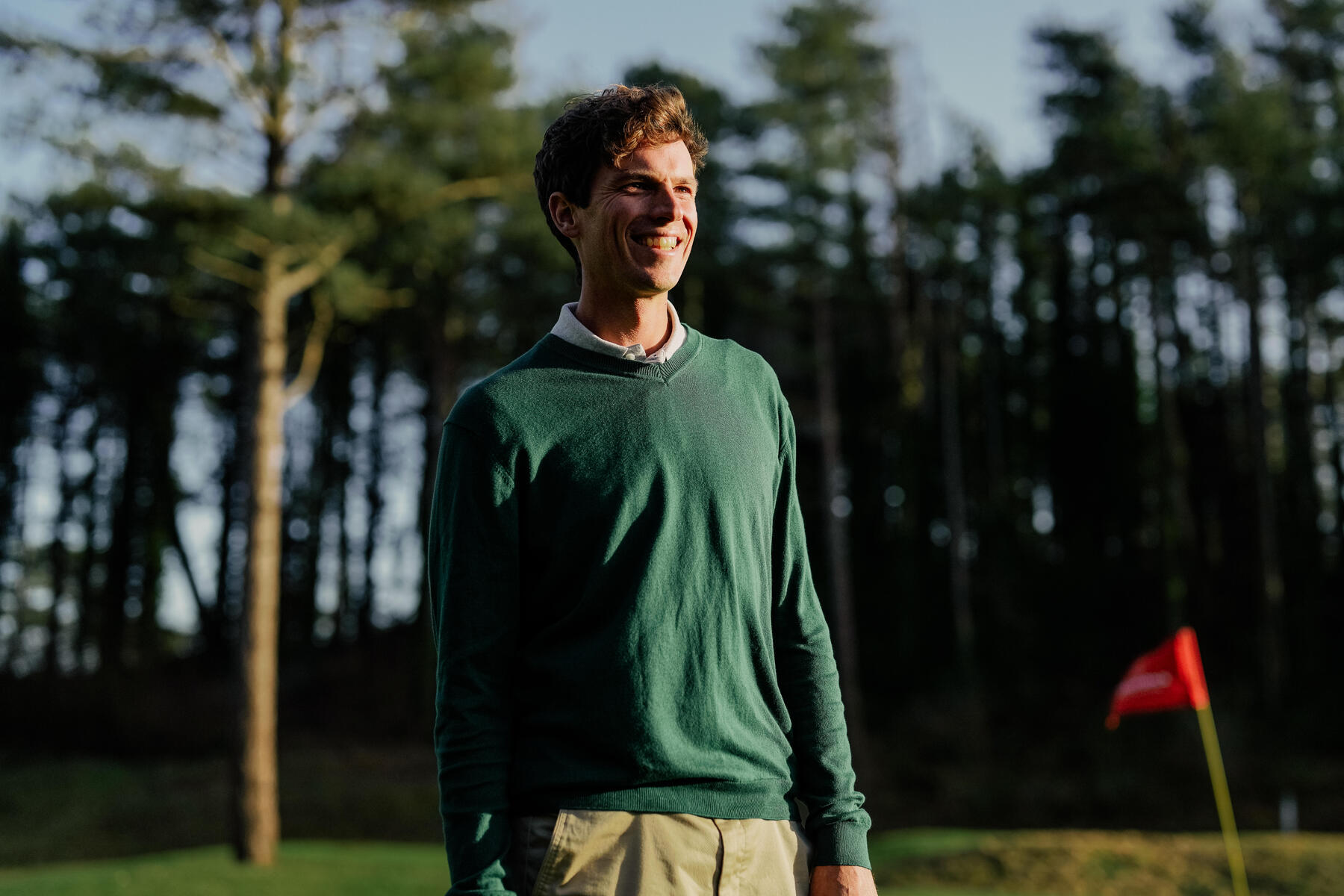 Mężczyzna w swetrze na polu golfowym