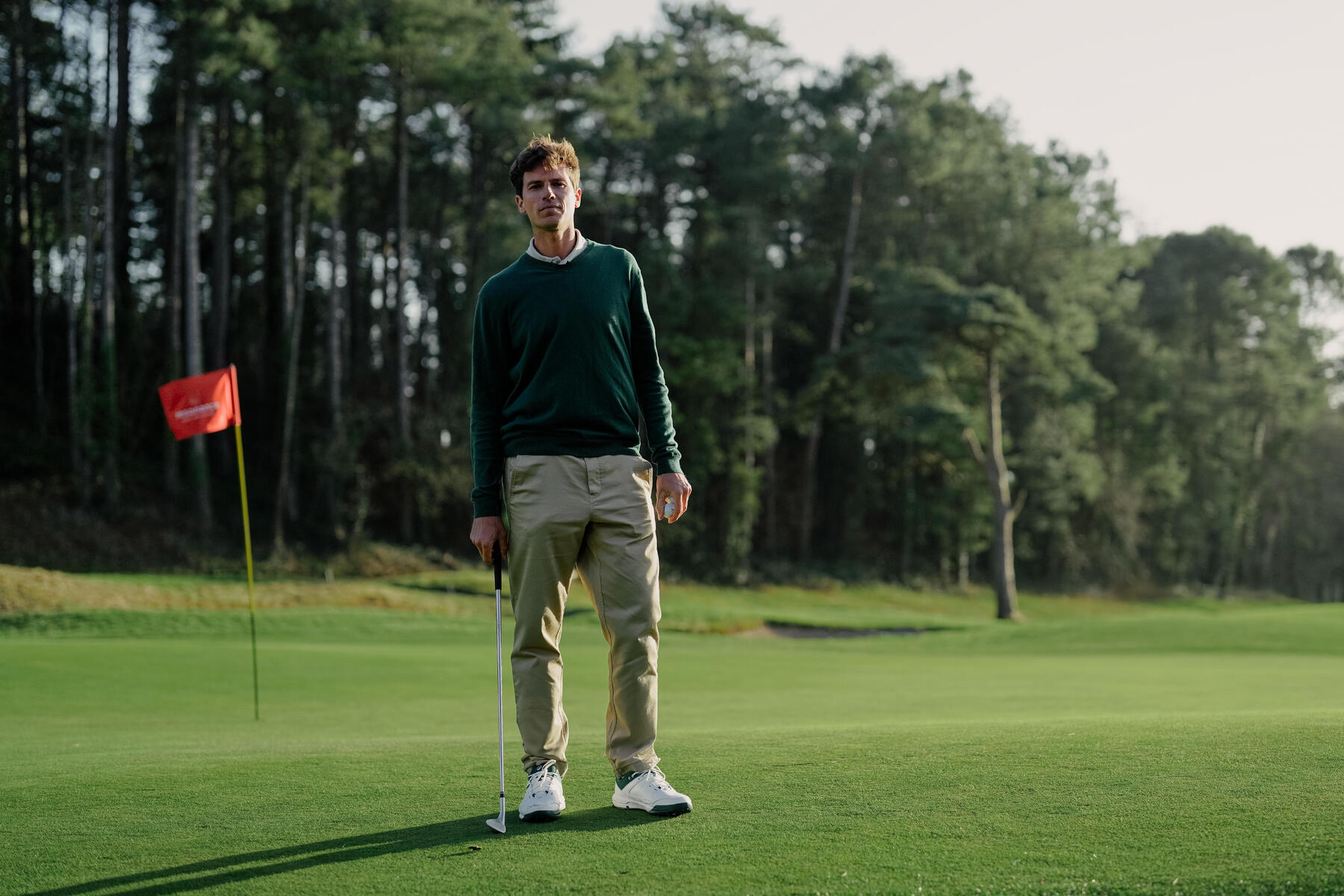 Mężczyzna stojący z kijem na polu golfowym