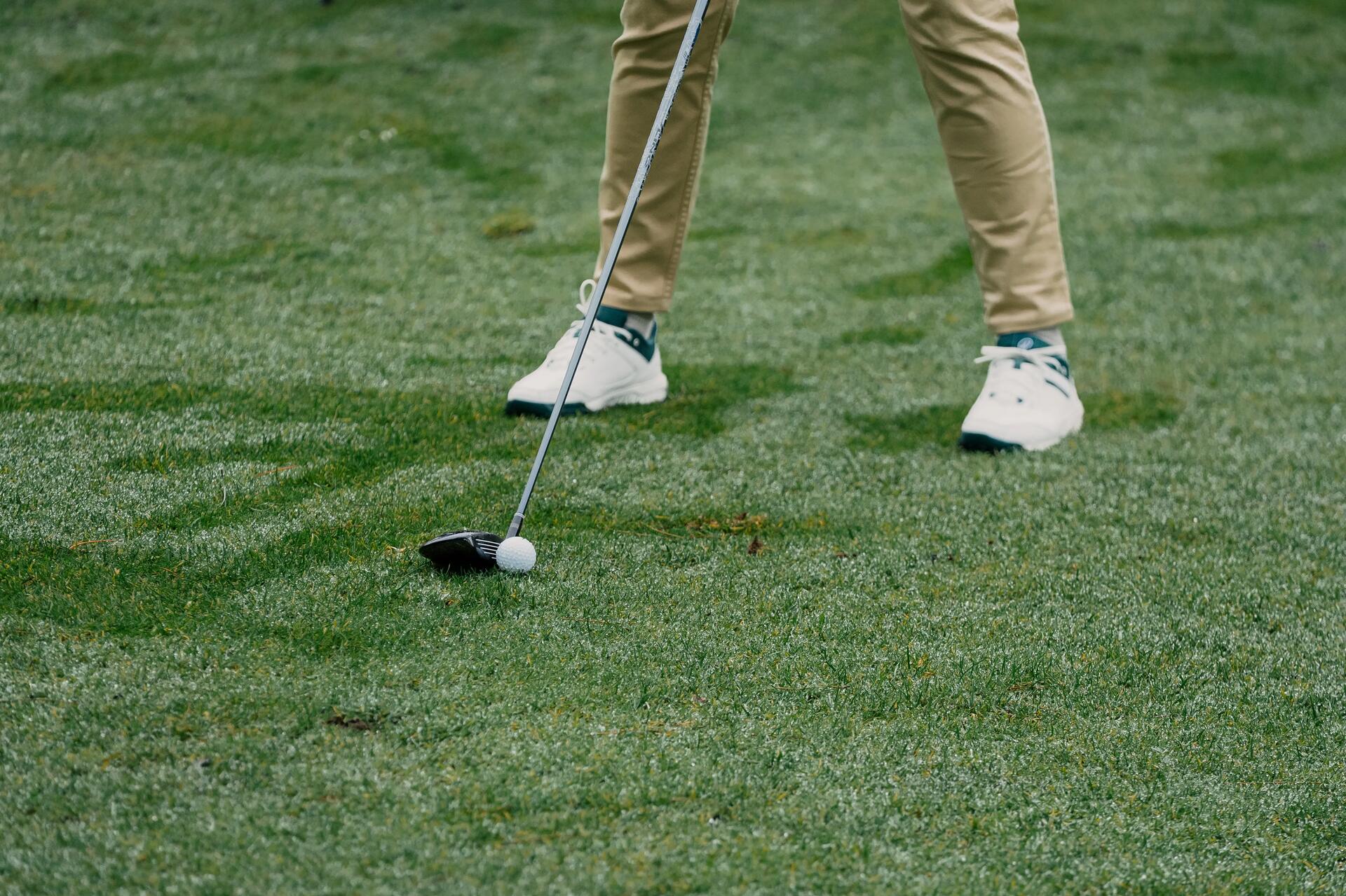 Mężczyzna uderzający kijem golfowym w piłkę