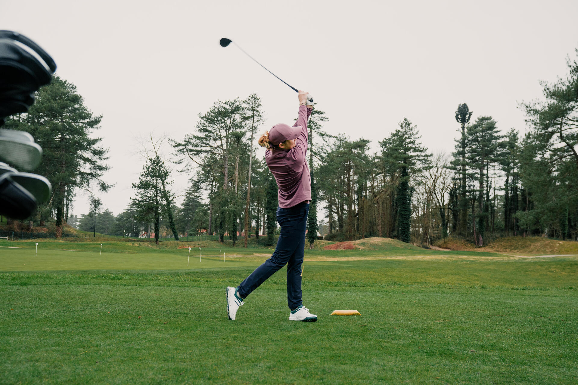 Kobieta wykonująca zmach kijem golfowym