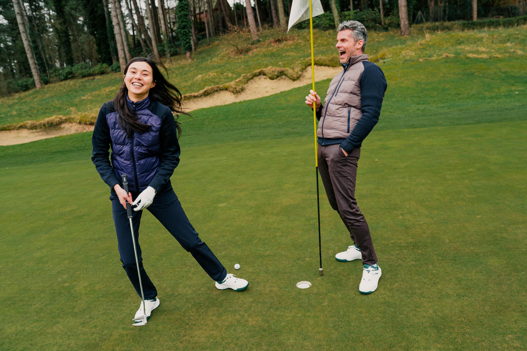 Kobieta i mężczyzna na polu golfowym z kijami