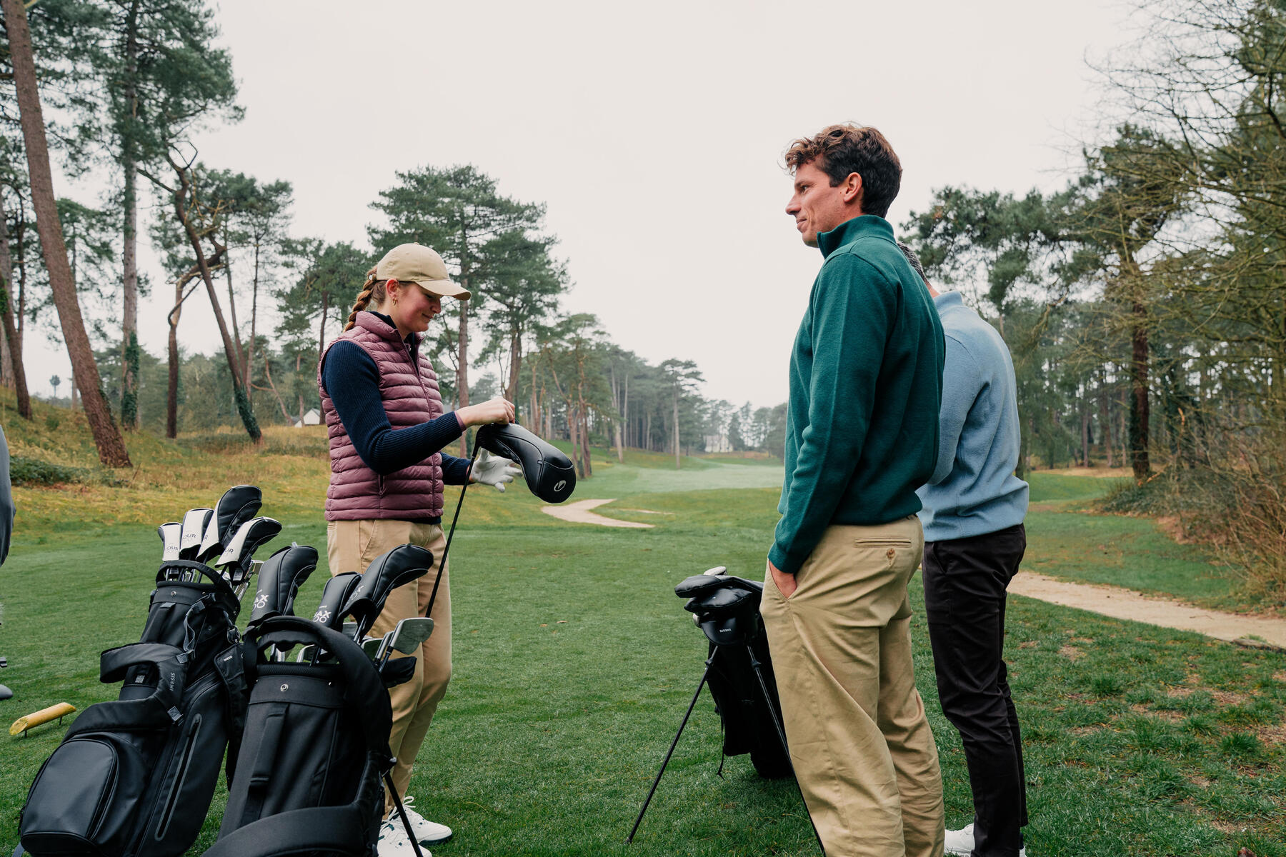 Ludzie ze sprzętem golfowym na polu golfowym