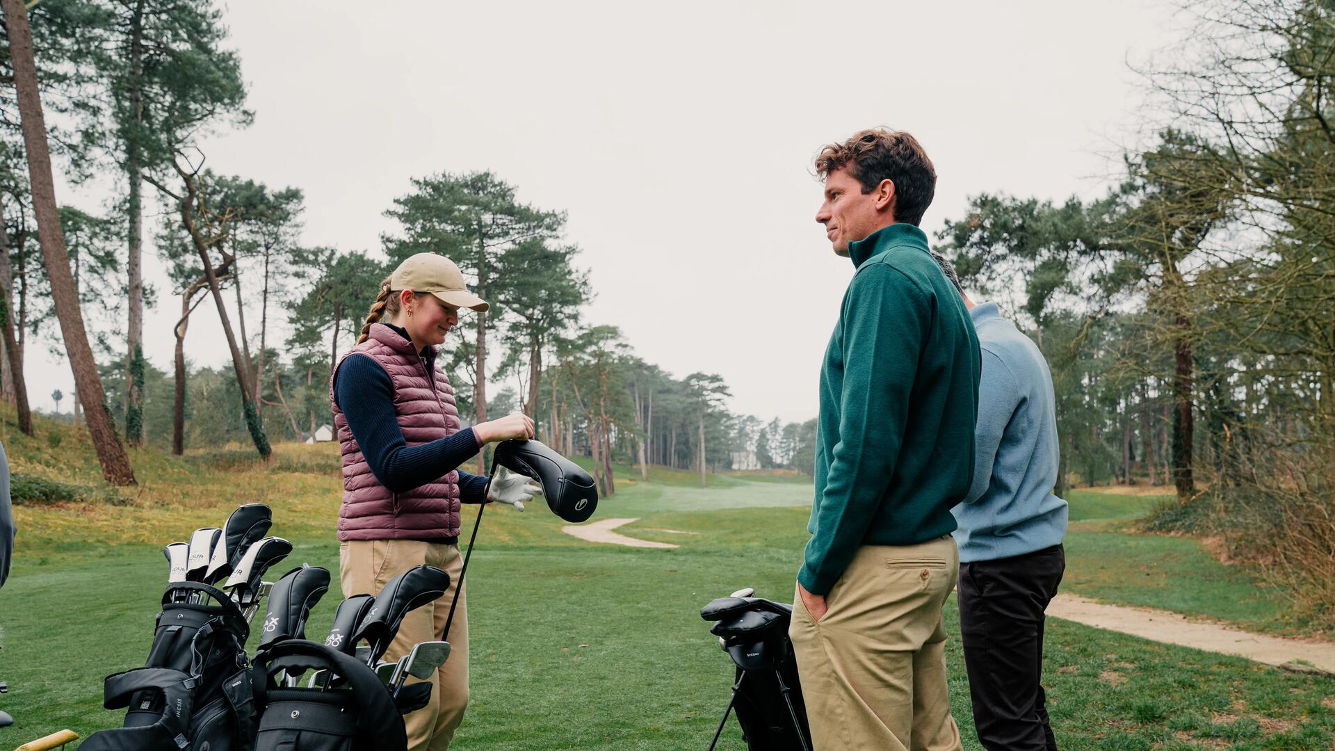 Ludzie ze sprzętem golfowym na polu golfowym