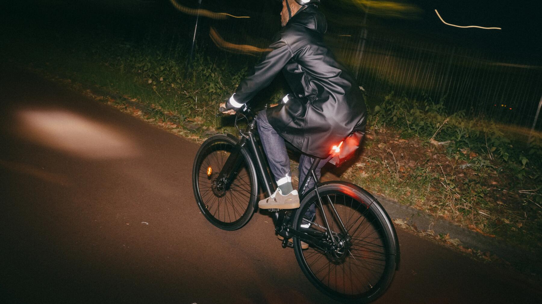 Mann fährt im Dunkeln mit seinem Fahrrad
