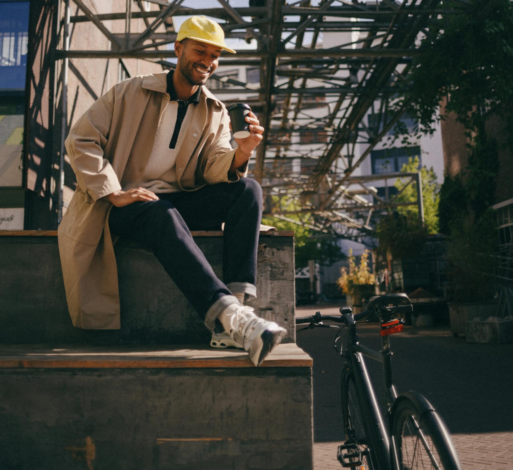 Mann mit gelber Cap sitzt neben seinem Fahrrad