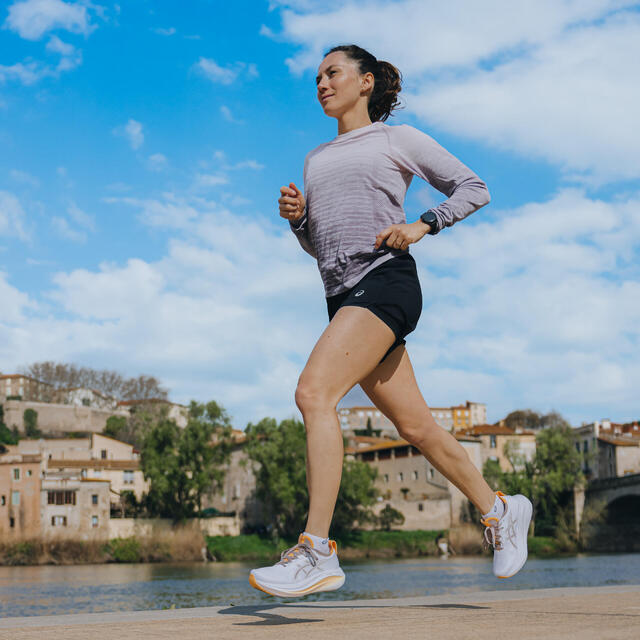 Žena trči pored reke u gradu