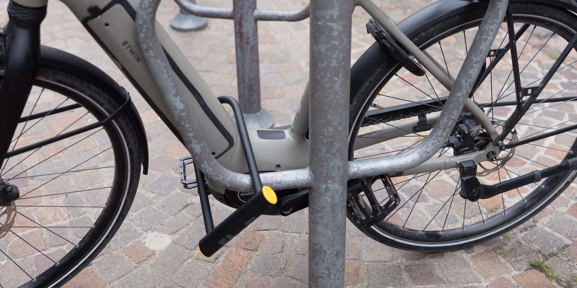 Een fiets die vastgemaakt is met een beugelslot (U-slot) aan een fietspaal in een stad
