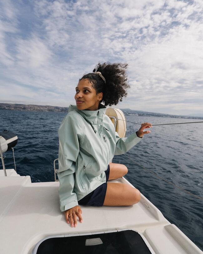 woman sailing wearing a white jacket with a high collar