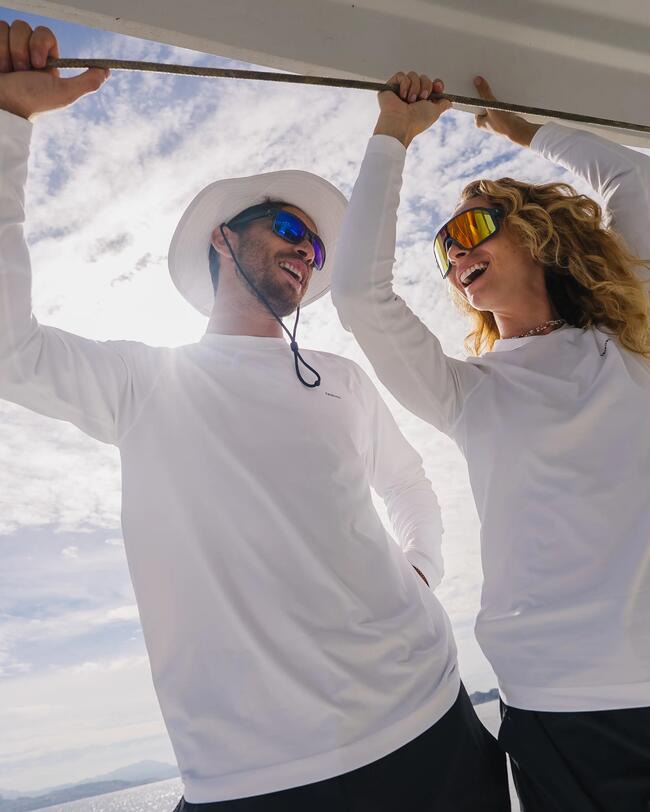 un homme et une femme en t shit anti uv sur un bateau