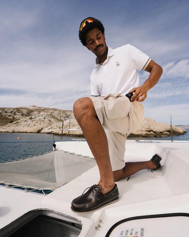 un homme sur un catamaran, en chaussures bateau