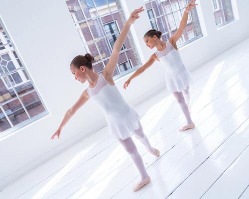 Zwei Balletttänzerinnen beim Training in einem hellen Tanzstudio