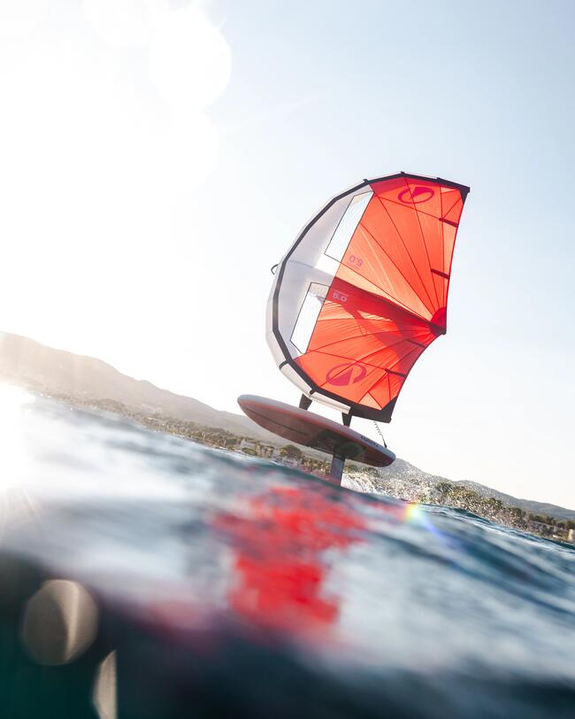 Un rider in wing foil al mare, ala da wing e tavola rosse