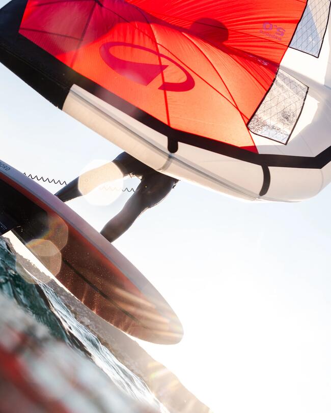 un rider in wing foil con un'ala rossa