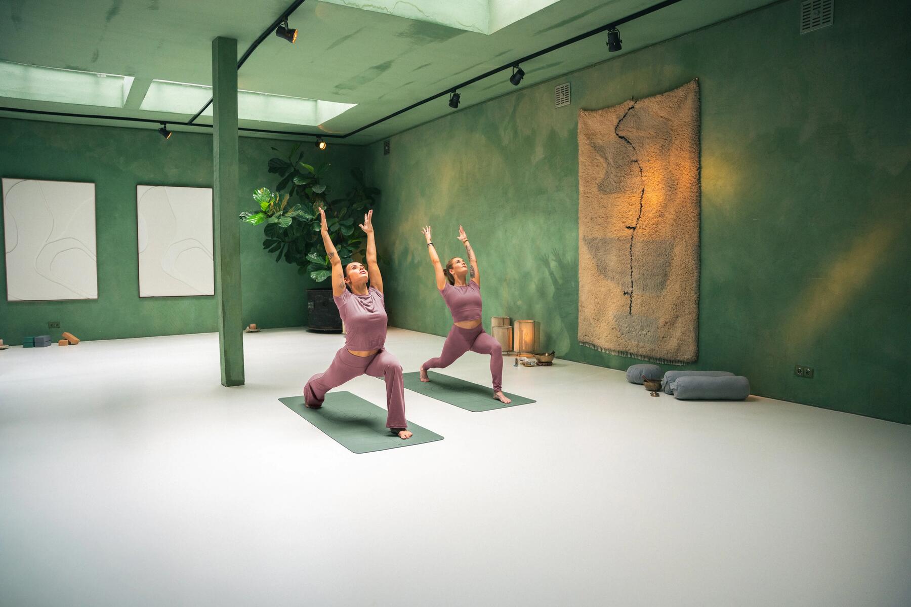 man holding a yoga pose on his mat