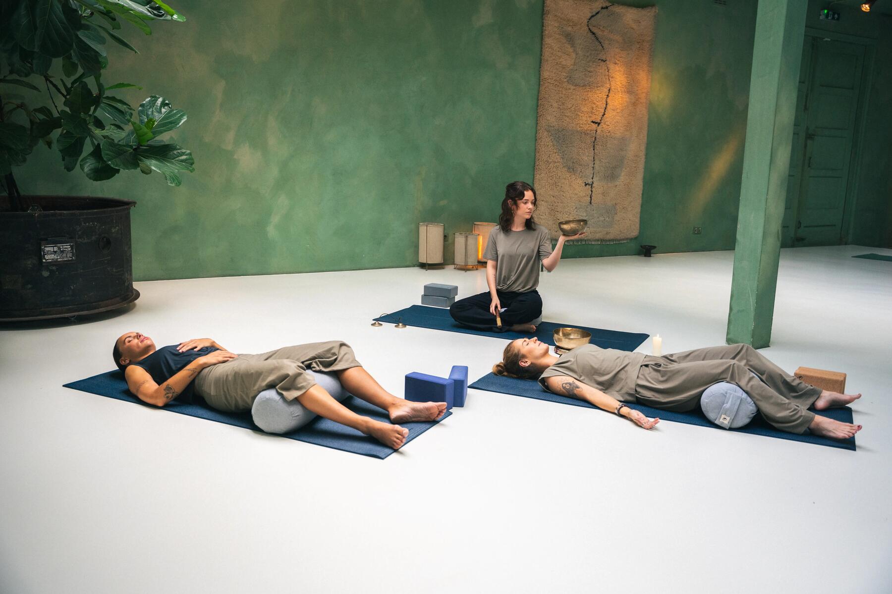 Zwei Freundinnen liegen auf Yogarollen