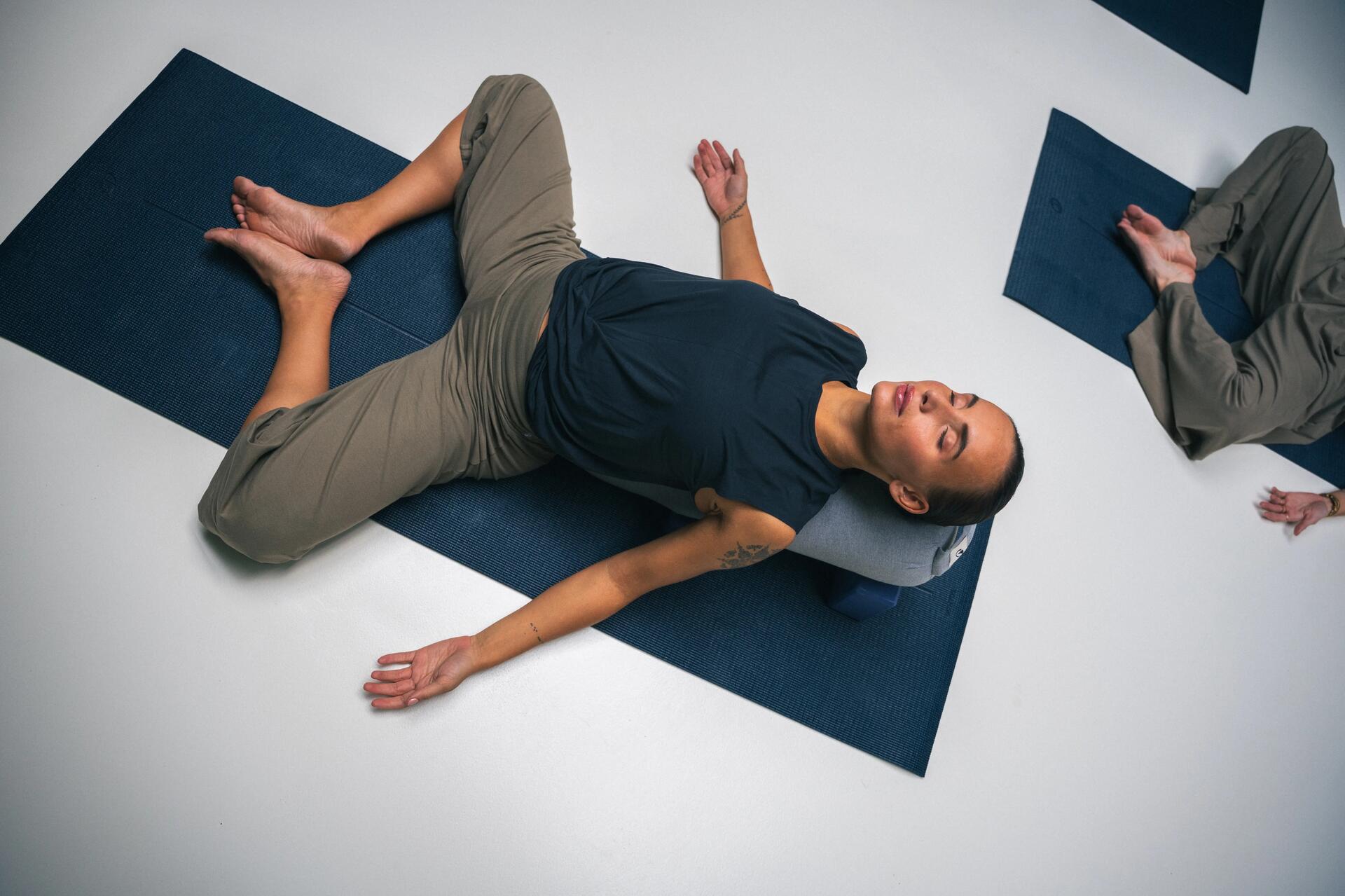 femme qui fait du pilates sur son tapis à la maison