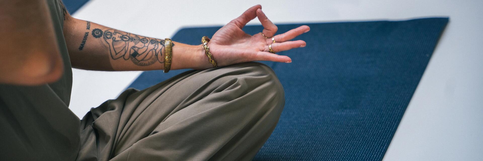 Kobieta siedząca na macie ćwicząca jogę kundalini