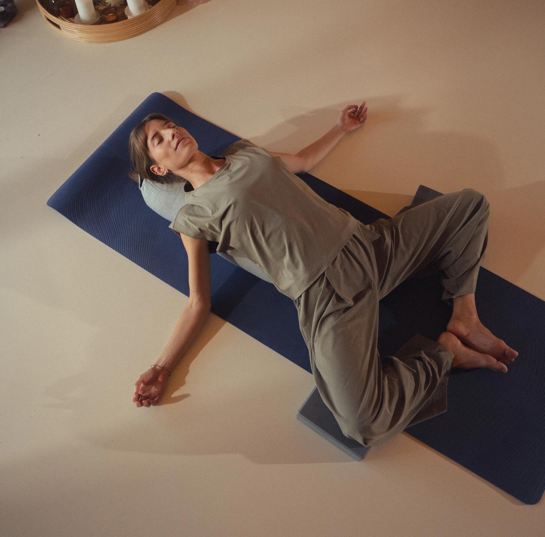Frau entspannt auf Yogamatte bei Meditation