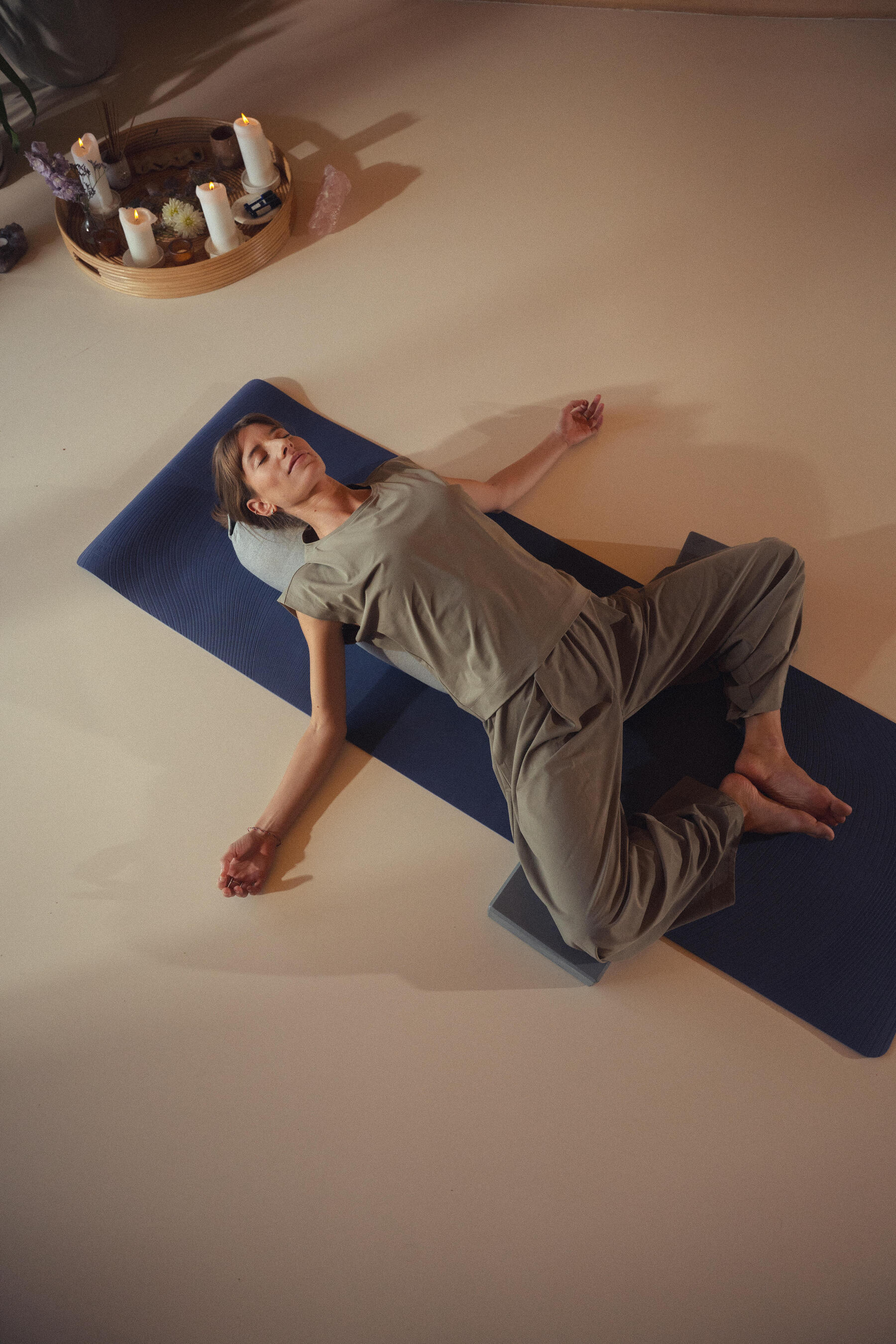 Entspannte Person liegt in Savasana auf dem Rücken für die Endentspannung nach dem Yoga.