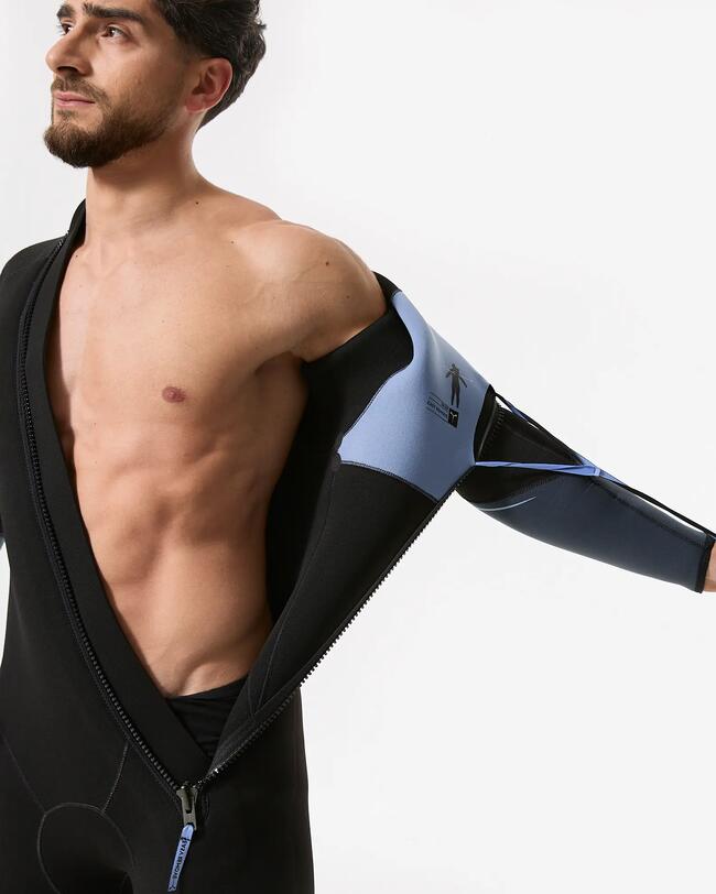 Plongeur dégageant d'un geste son épaule d'une combinaison de plongée noire avec long zip en diagonale en tirant sur la lanière bleue du système d'aide à l'enlevage.