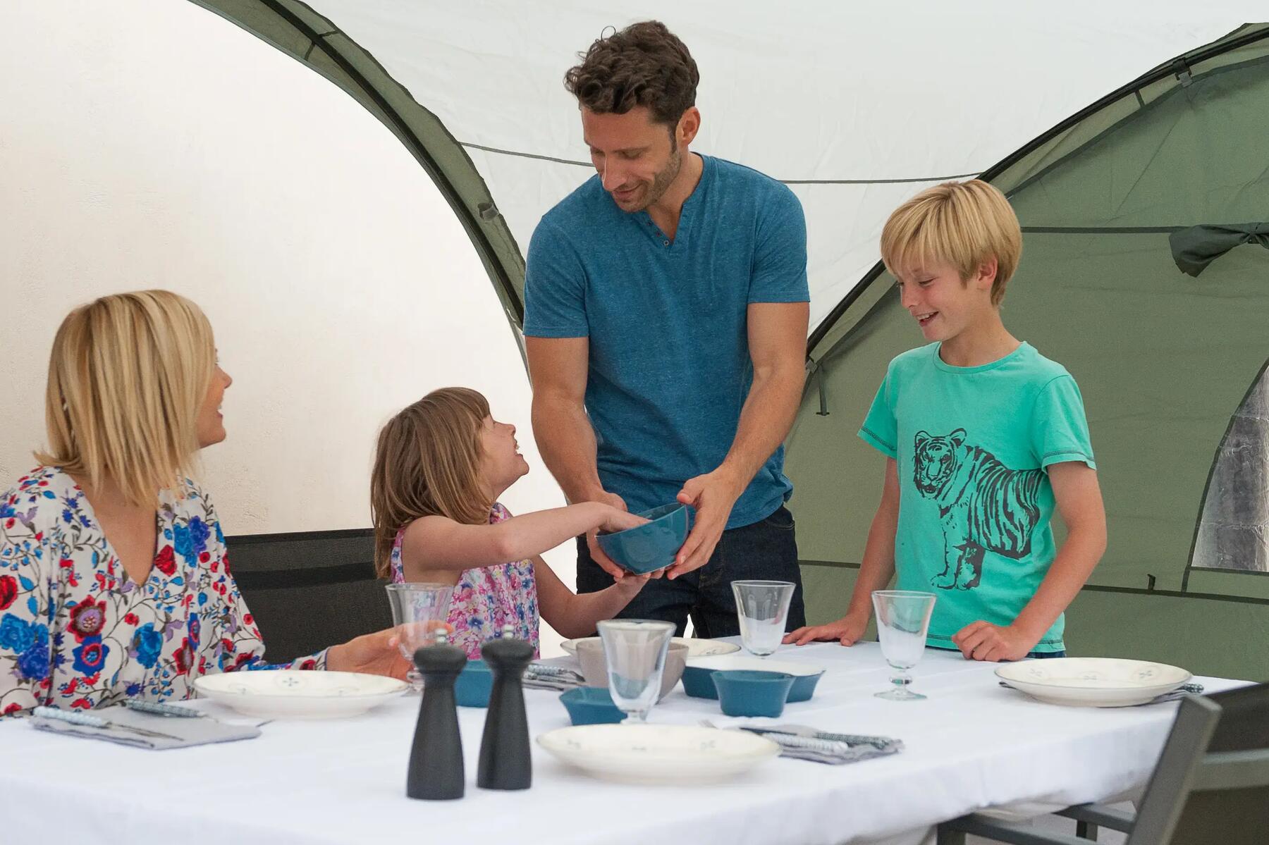 Mann und Frau nutzen Campinggeschirr mit ihren beiden Kindern