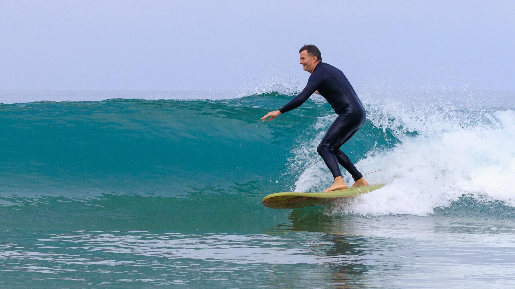 woman with here surf board under the arm walking on a beach