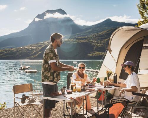 Personnes qui campent au bord d'un lac avec des lunettes de soleil