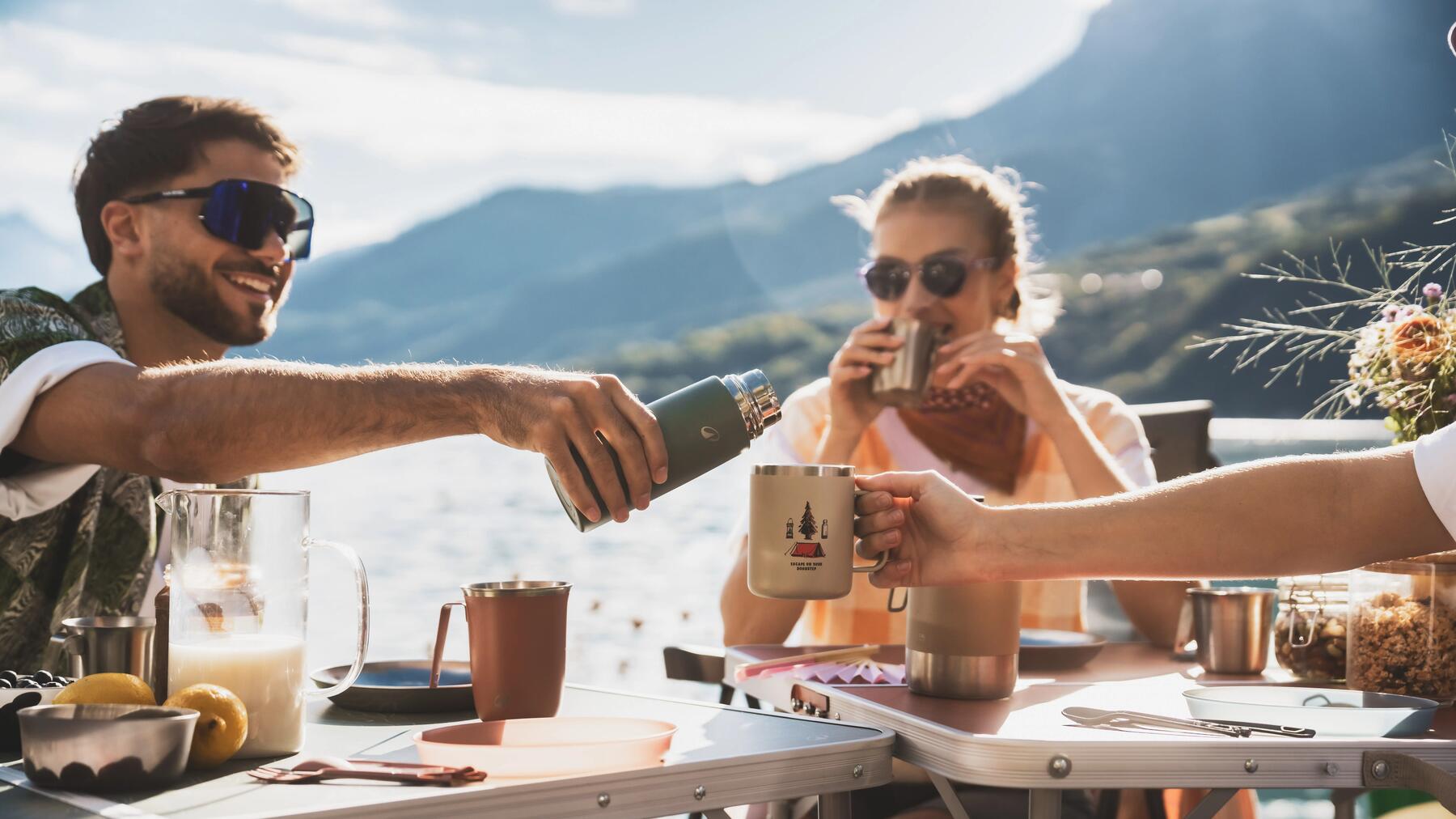 A woman reads comfortably in a tent with a mattress, sleeping bag, and light
