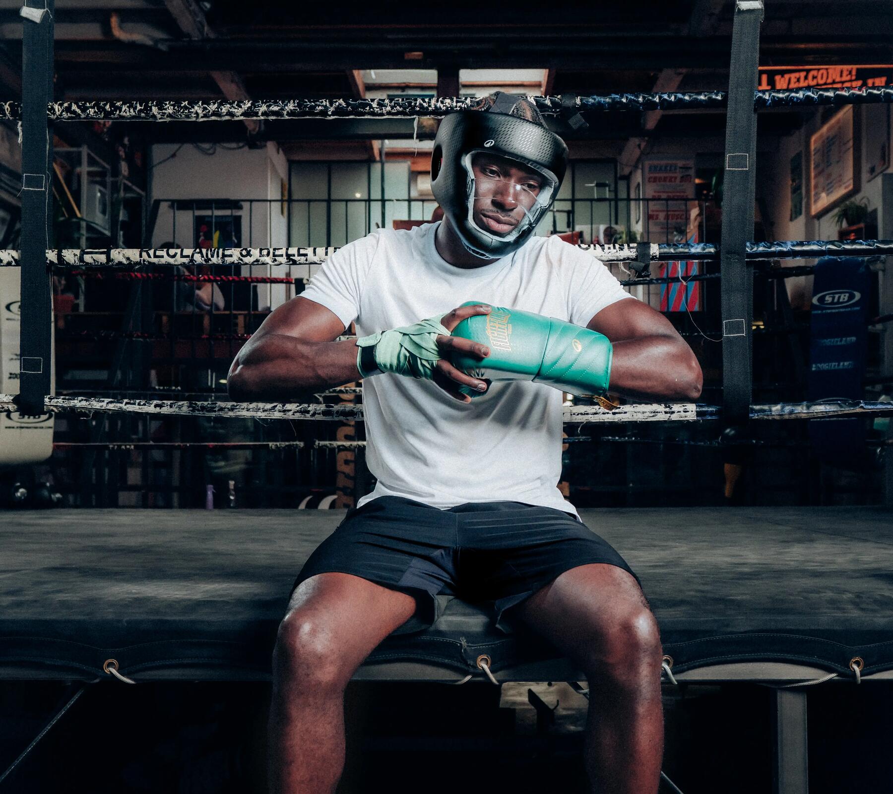 Ein Boxer sitzt am Ring mit aufgehängtem Boxsack