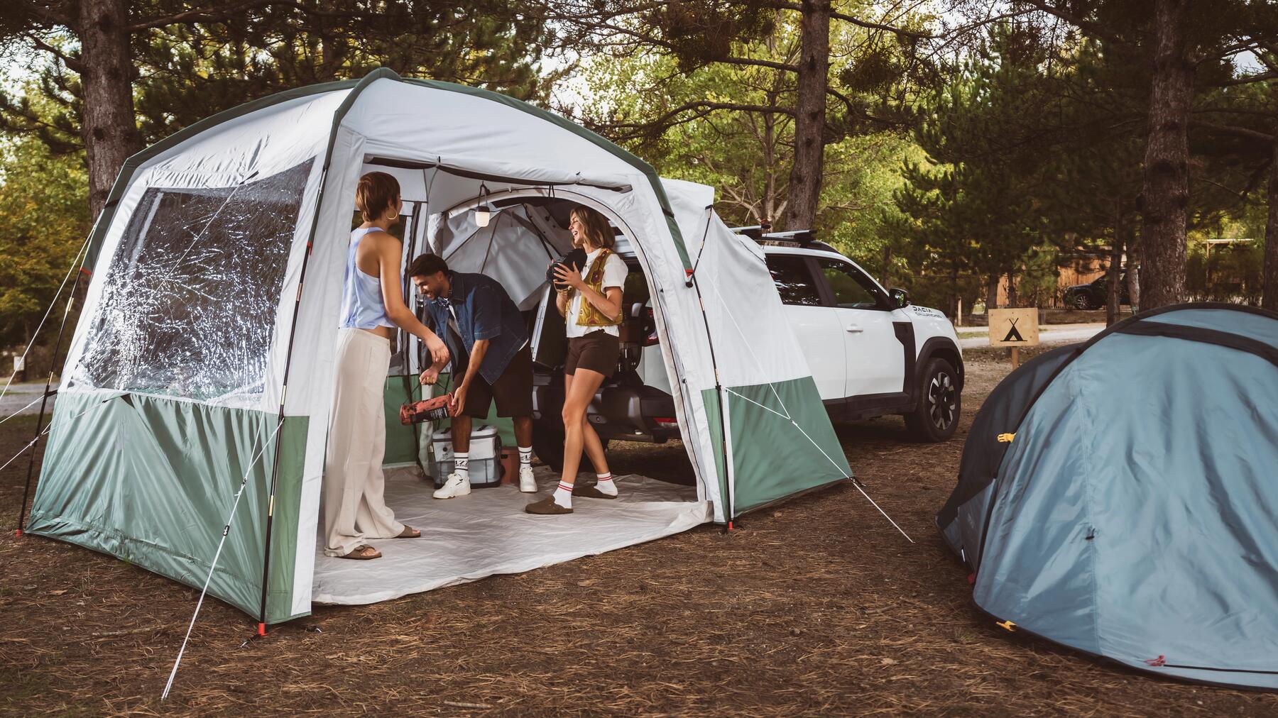Ein großes Zelt steht im Wald und hat eine Camping-Kühltasche darin